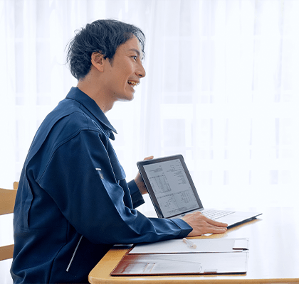 タブレットを見ながら笑顔で打ち合わせをする職人